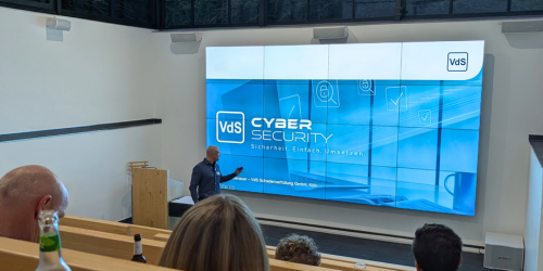 Cyber Security Vortrag bei Ebbtron Hagen: Referent präsentiert VdS Cyber Security auf großer Videowall im modernen Auditorium für Business Events und Schulungen