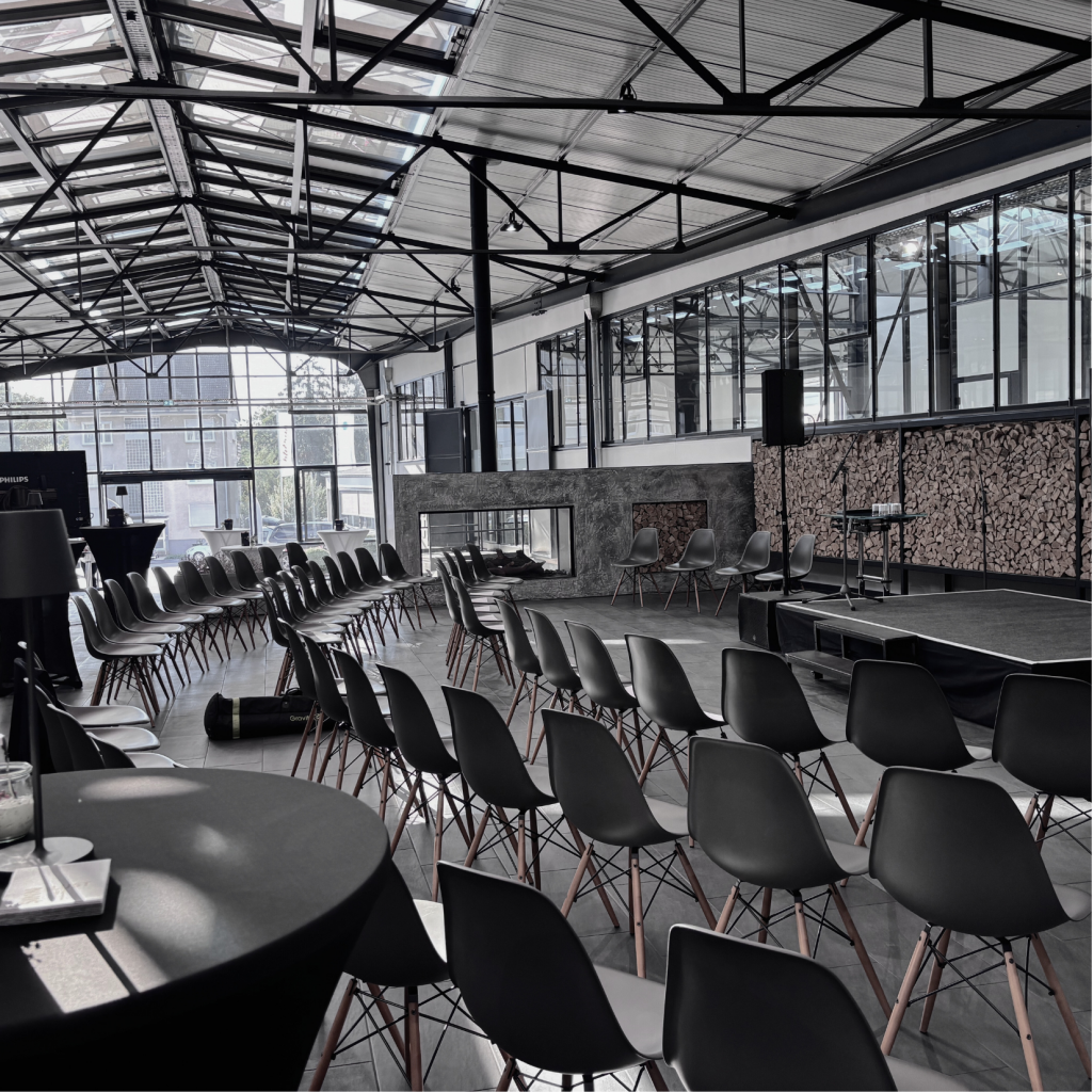 Eventlocation Ebbtron in Solingen mit moderner Bestuhlung und Bühne im lichtdurchfluteten Atrium für Konferenzen, Podiumsdiskussionen und Networking-Events im Bergischen Land.