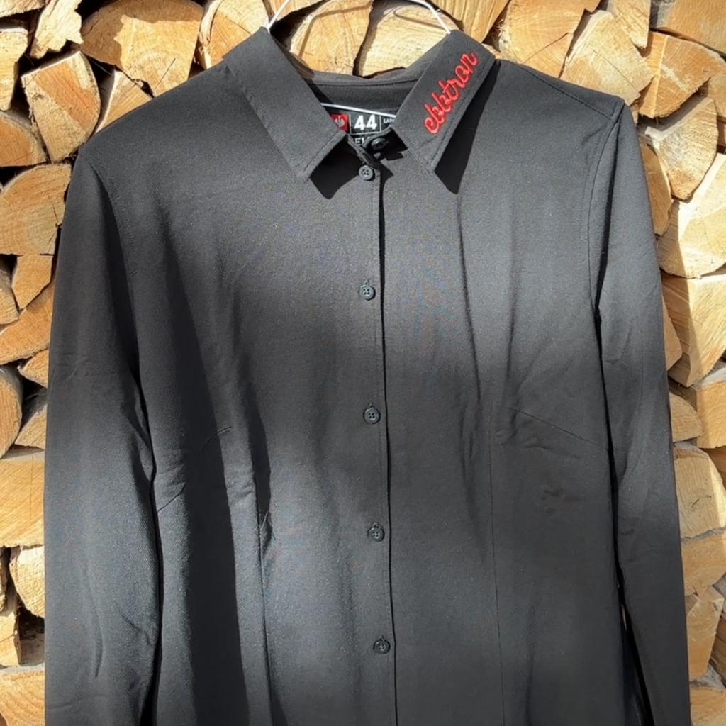 Schwarze Servicebluse mit gesticktem Ebbtron Logo am Kragen – neue Arbeitskleidung des Event- und Serviceteams im Ebbtron Solingen.