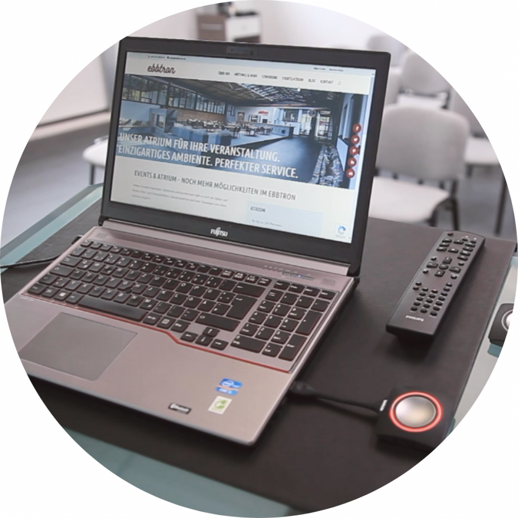 Laptop mit angeschlossener Konferenztechnik im Ebbtron – die Technik wird für Präsentationen, hybride Meetings oder Videokonferenzen eingerichtet.